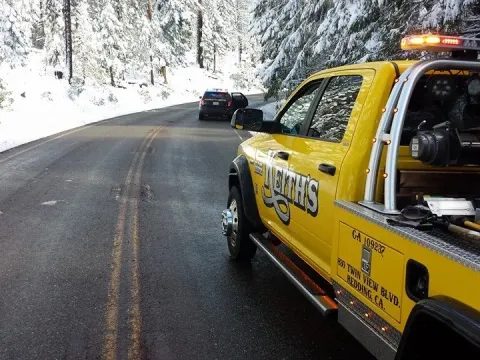 Keith's Towing truck responding to a call on a snowy mountain road near Redding, CA