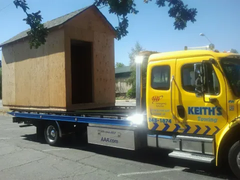 Keith's Towing crew recovering a shed loaded onto a flatbed