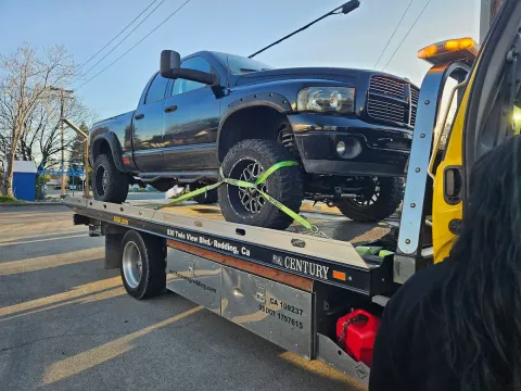 Keith's Towing flatbed truck towing a pickup