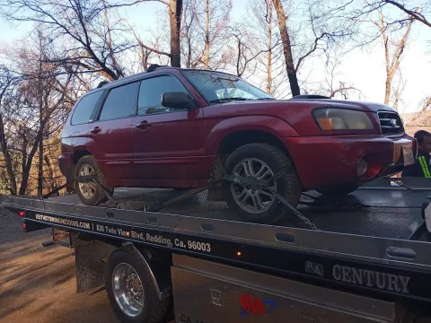 Keith's Towing flatbed truck with an SUV loaded for transport